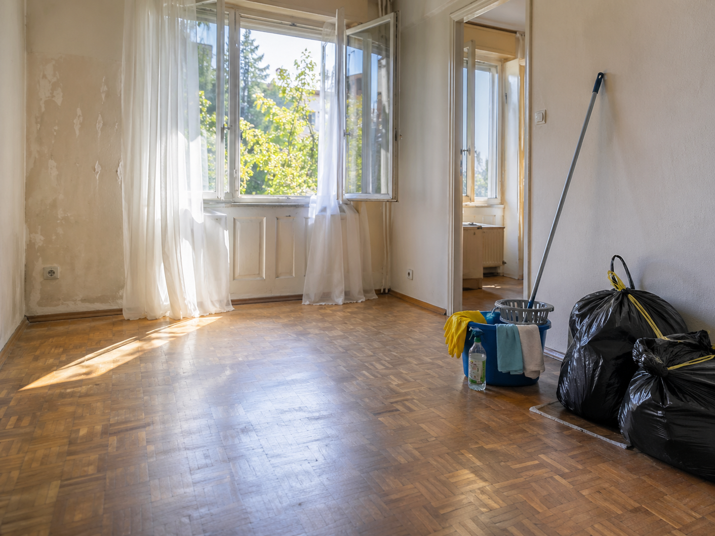 Aération d’un logement après un nettoyage de syndrome de Diogène avec fenêtres ouvertes, matériel de nettoyage et sacs de déchets